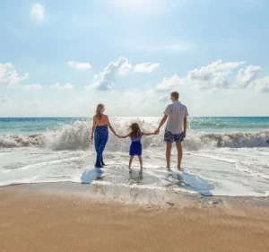 Familie am Strand vor Welle