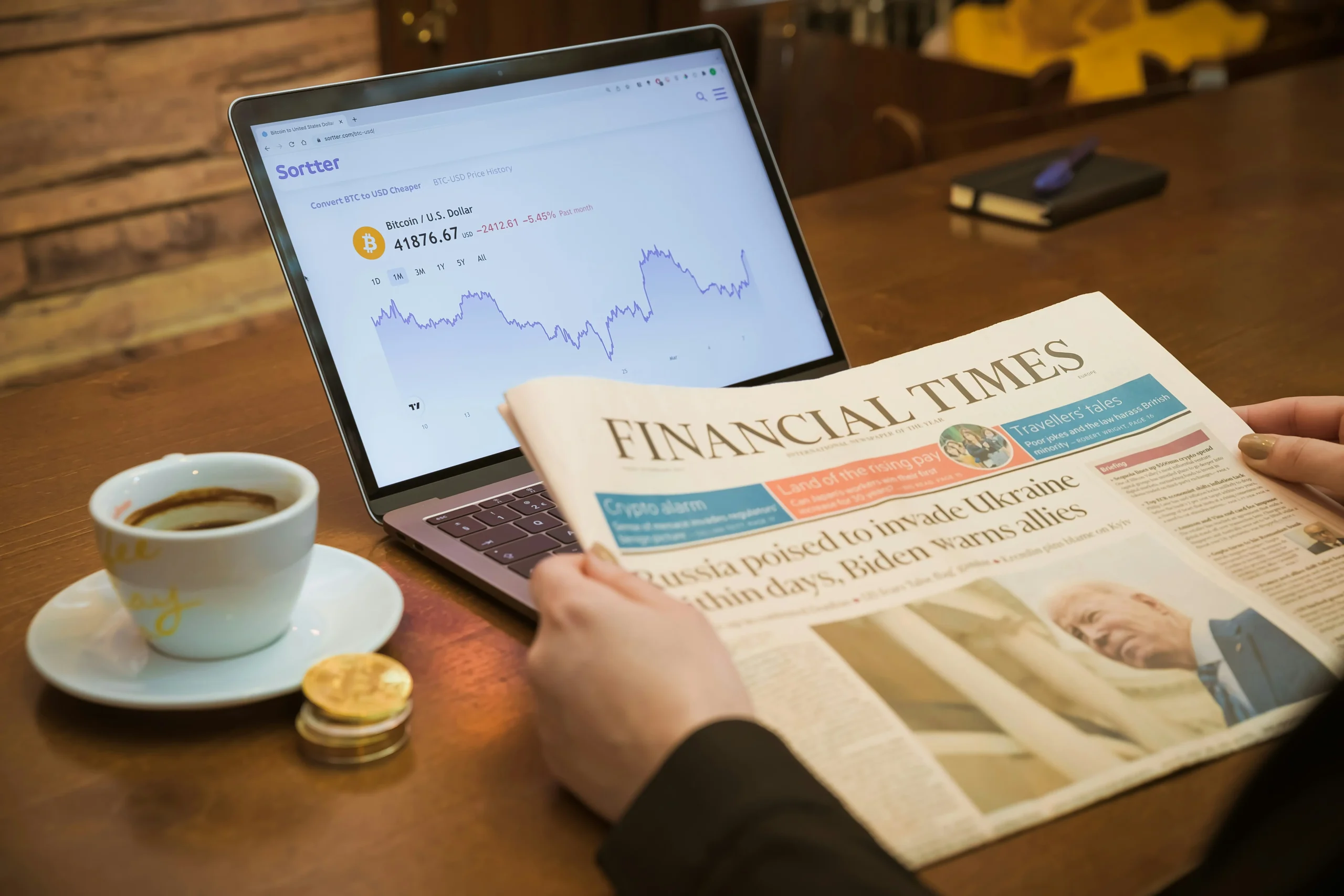 Eller Consulting Altersvorsorge: Laptop mit Bitcoinkurs eine Zeitung der Financial Times und daneben ein Kaffee